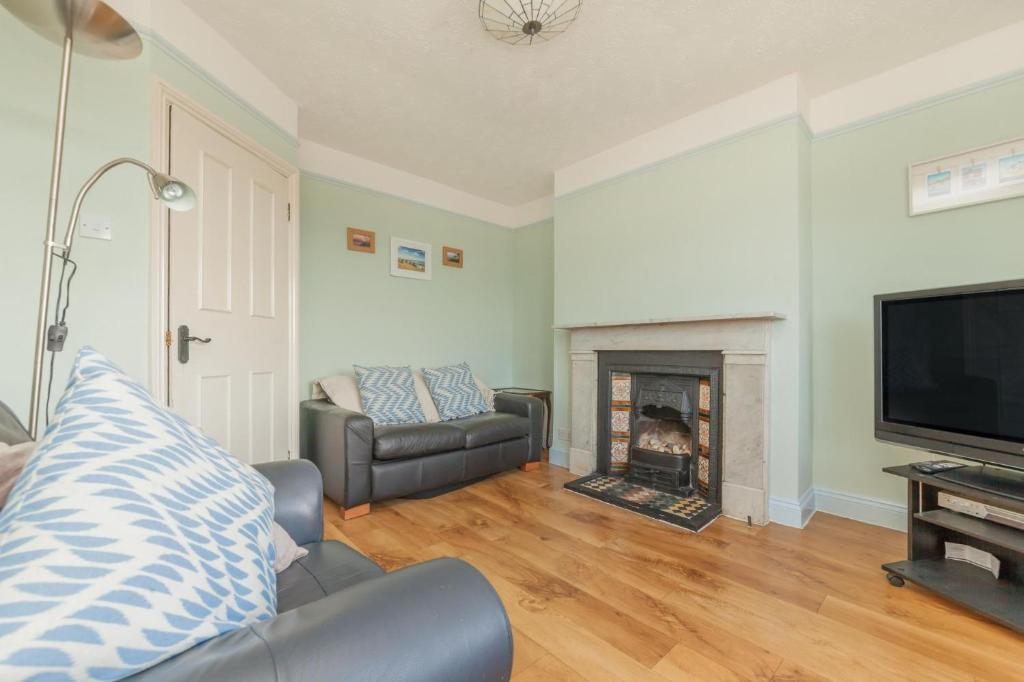 a living room with a couch and a fireplace at Pilgrim's Lookout Whitstable Holiday Home in Whitstable