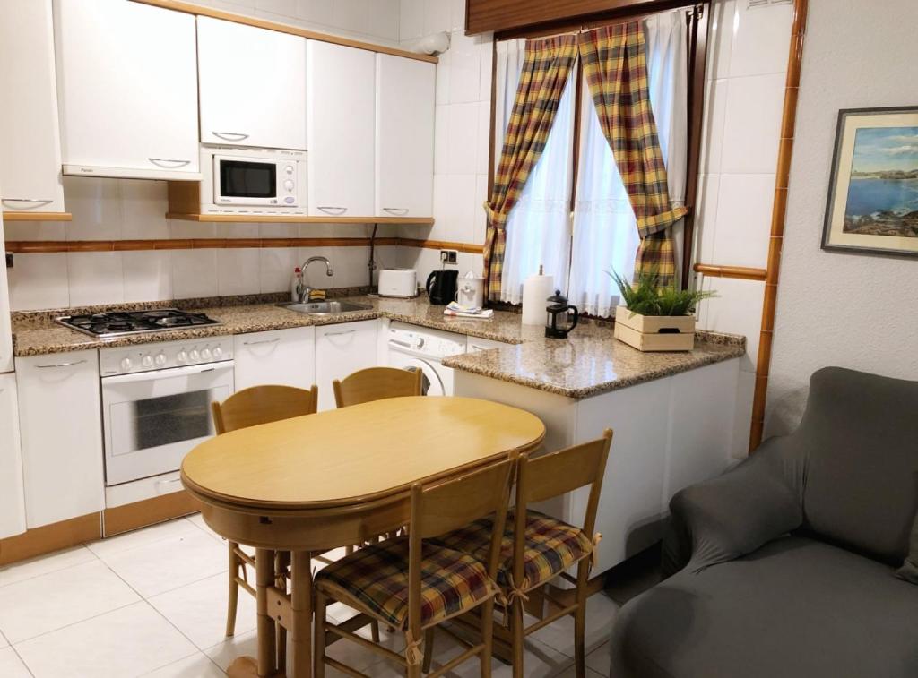 uma pequena cozinha com uma mesa de madeira e uma mesa em Clasico y funcional apartamento centro bilbao by urban hosts em Bilbao