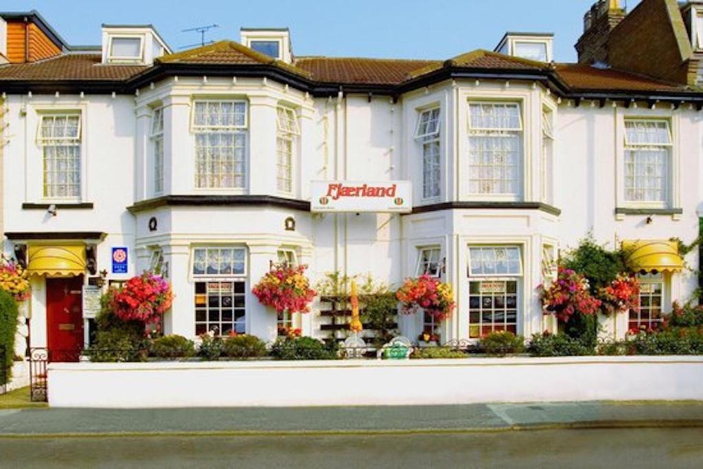 a white building with flowers in front of it at Fjaerland Hotel in Great Yarmouth