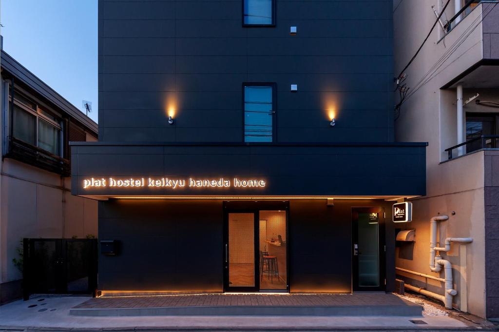 a building with a sign that readsbutt hospital healthy healing house at plat hostel keikyu haneda home in Tokyo