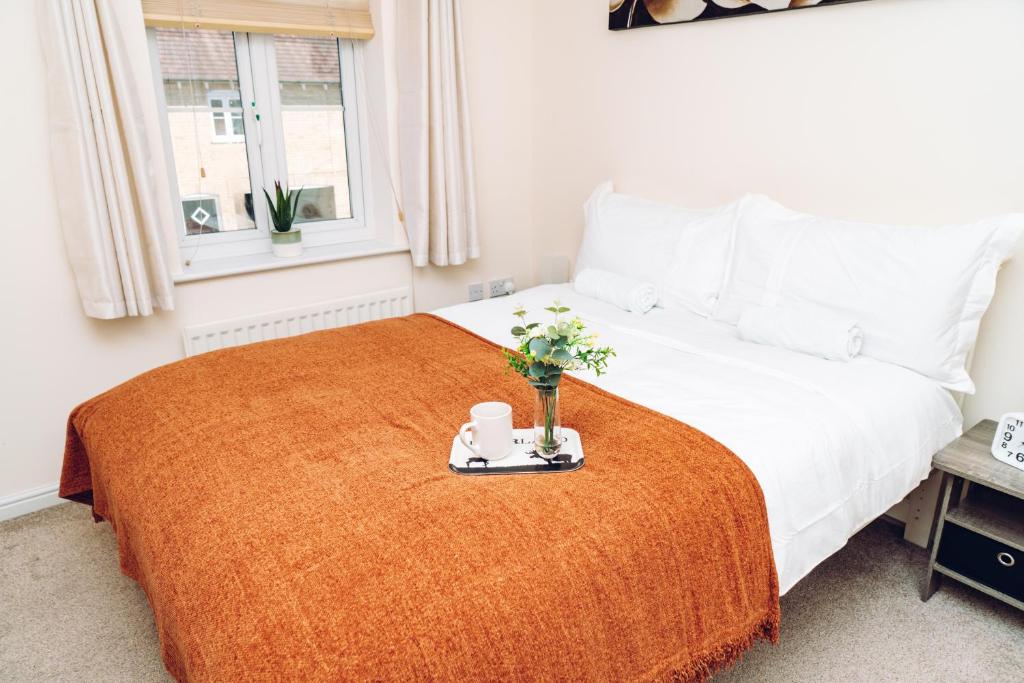 a bedroom with a white bed with a orange blanket at Comfortable Colchester Home in Colchester