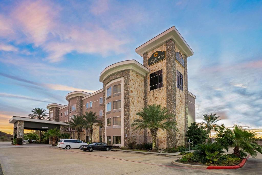 a large building with a clock tower in a parking lot at La Quinta by Wyndham Houston Willowbrook in Houston