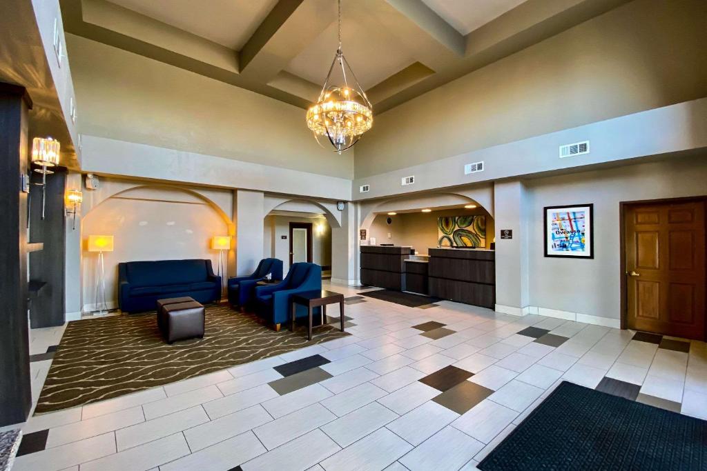 a lobby of a hospital with blue chairs and a chandelier at Comfort Inn Owasso – Tulsa in Owasso