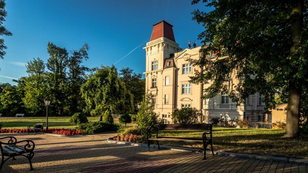 un edificio con panchine di fronte ad esso di Bristol Vila Tereza a Karlovy Vary