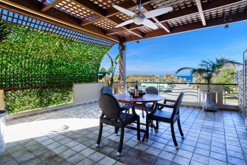 a table and chairs on a patio with a view at Xenios Dias Luxury Apartments With Sea View in Kato Daratso