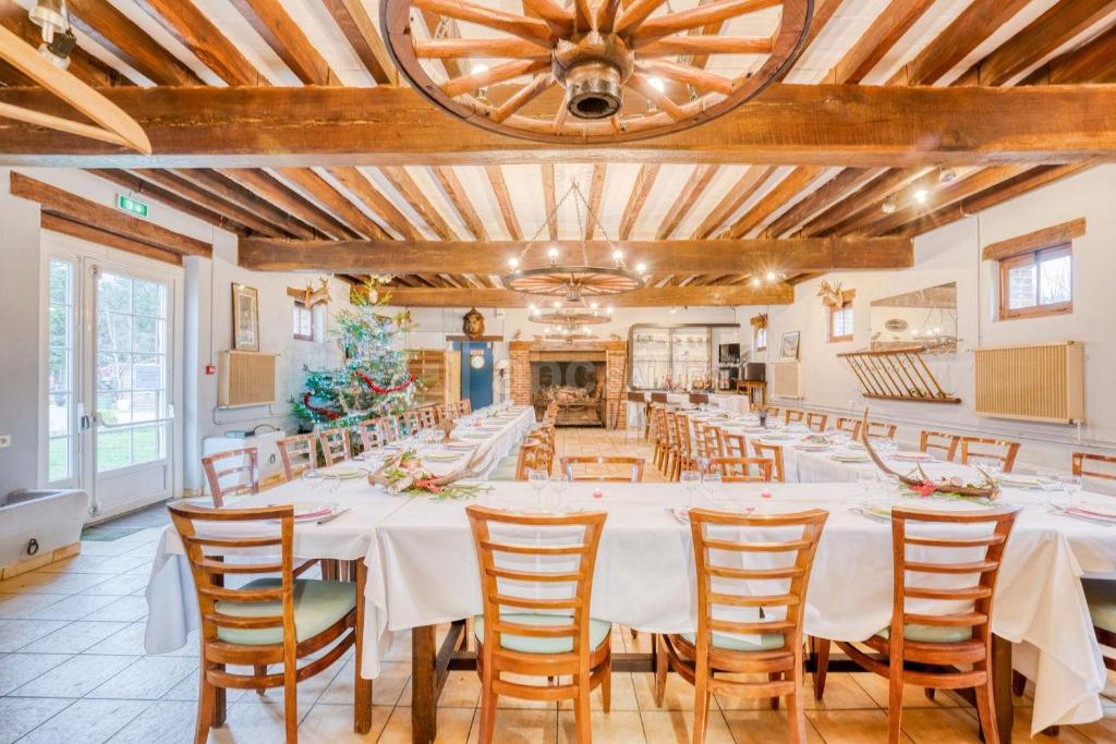 a large dining room with white tables and chairs at Auberge de villechaume in Sennely