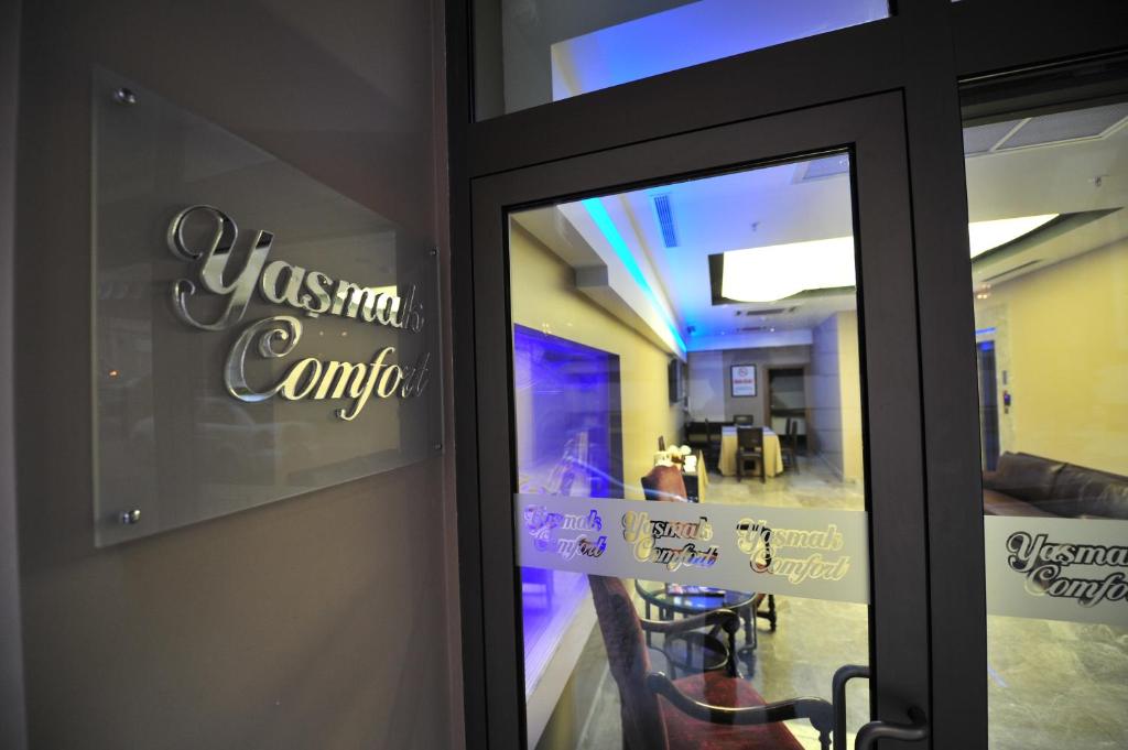 una puerta de cristal de un restaurante con mesa y sillas en Yasmak Comfort Hotel, en Estambul