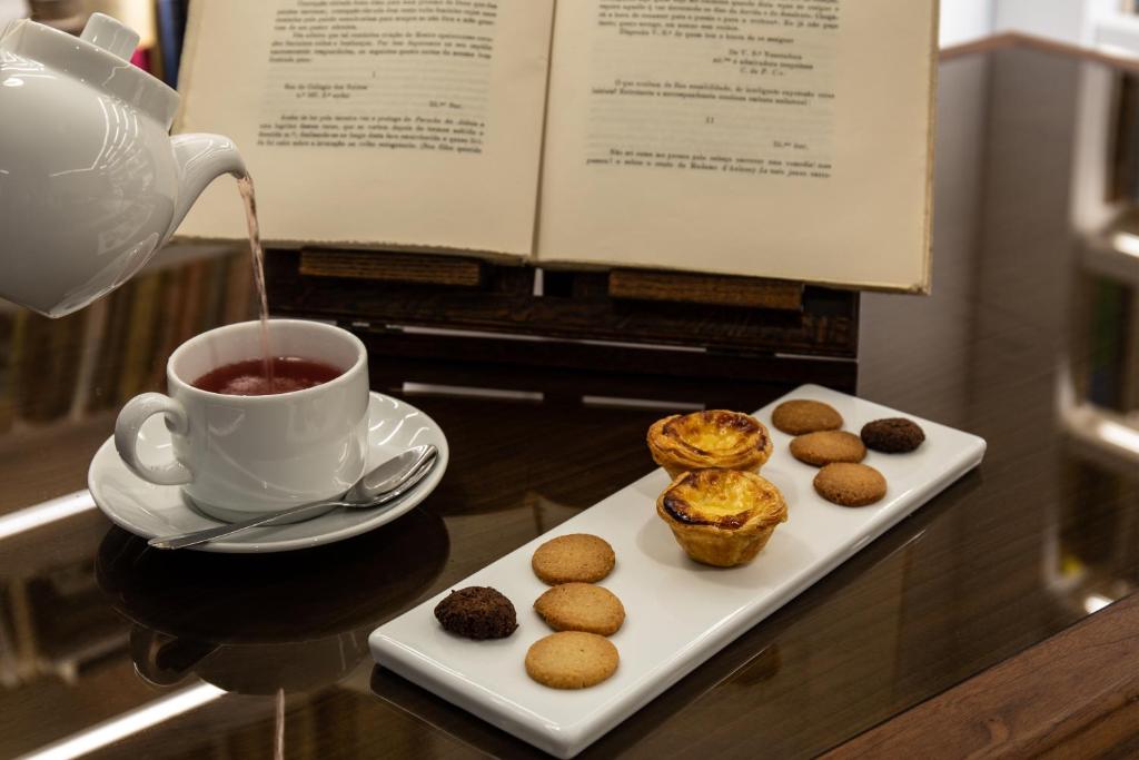 Tea and Portuguese pastries arranged beside an open menu.
