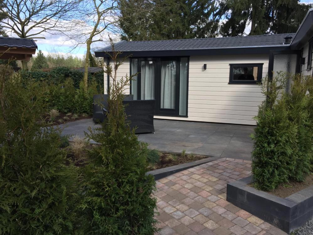 una casa con patio e una casa di Huisjes Putten Reewold luxe chalet in rustige en mooie omgeving a Putten