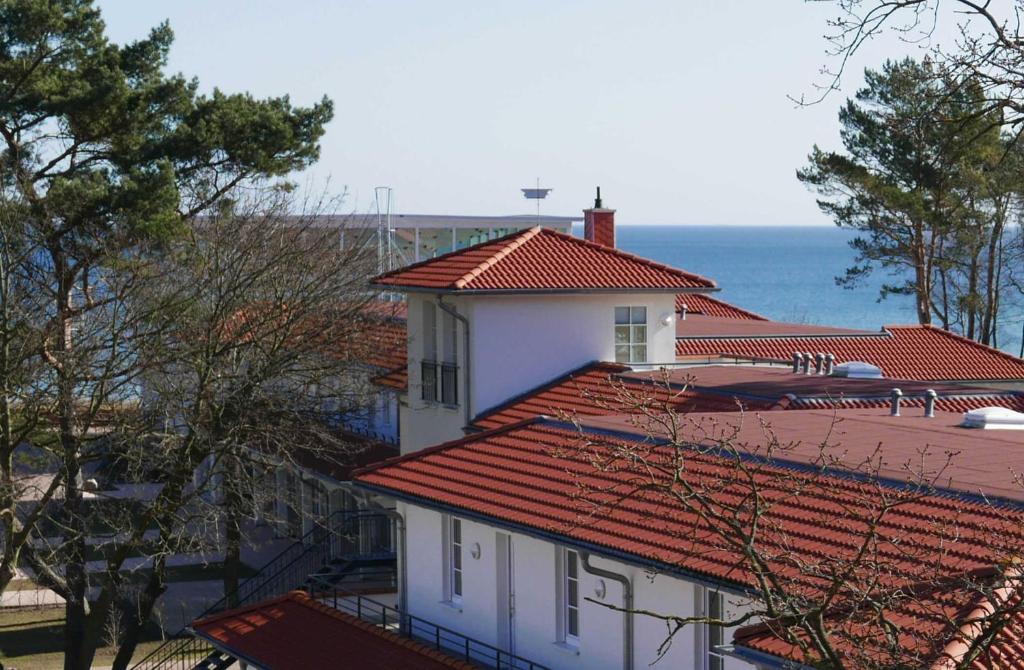 a white house with red tile roofs and the ocean at Baabe Inselparadies Fewo Bernstein in Baabe