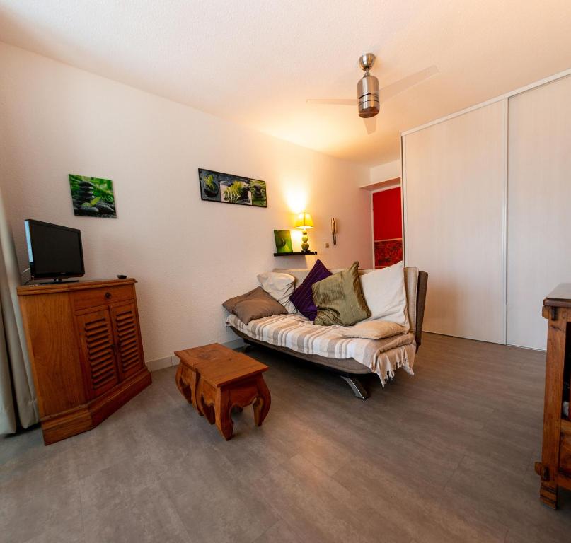 - un salon avec un canapé et une télévision dans l'établissement APPARTEMENT VUE SUR LE PORT, centre ville ST GILLES LES BAINS Ile de la réunion, à Saint-Gilles les Bains