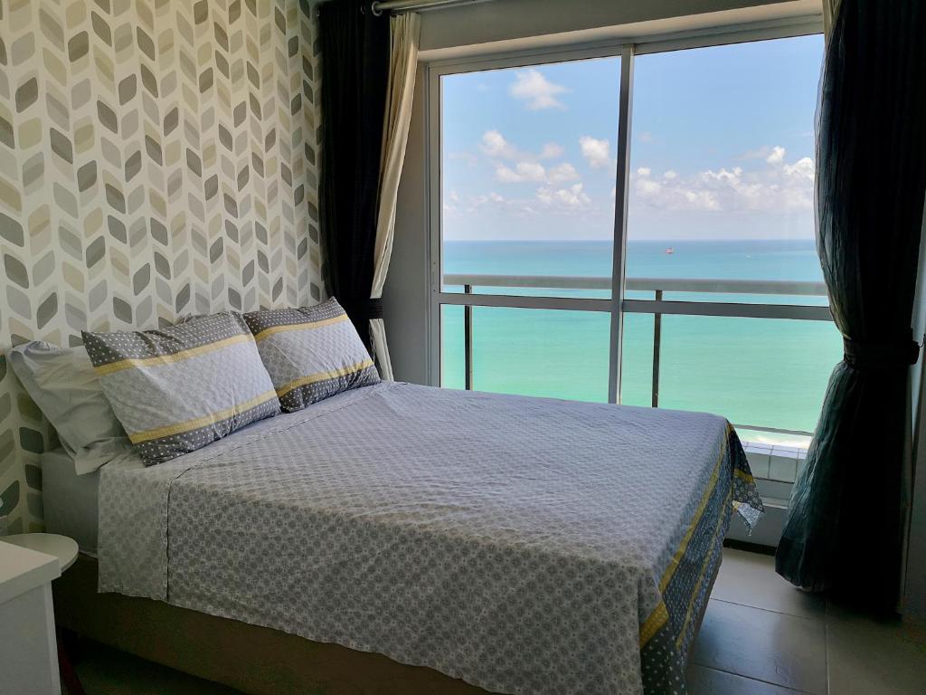 a bedroom with a bed with a view of the ocean at Modern Beachfront Apartment w. Magnificent Seaview in Fortaleza