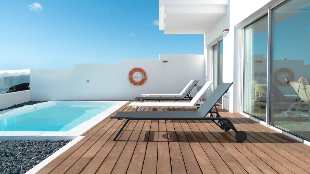 a house with a swimming pool and a deck at CalaLanzarote Suites Hotel - Adults Only in Playa Blanca
