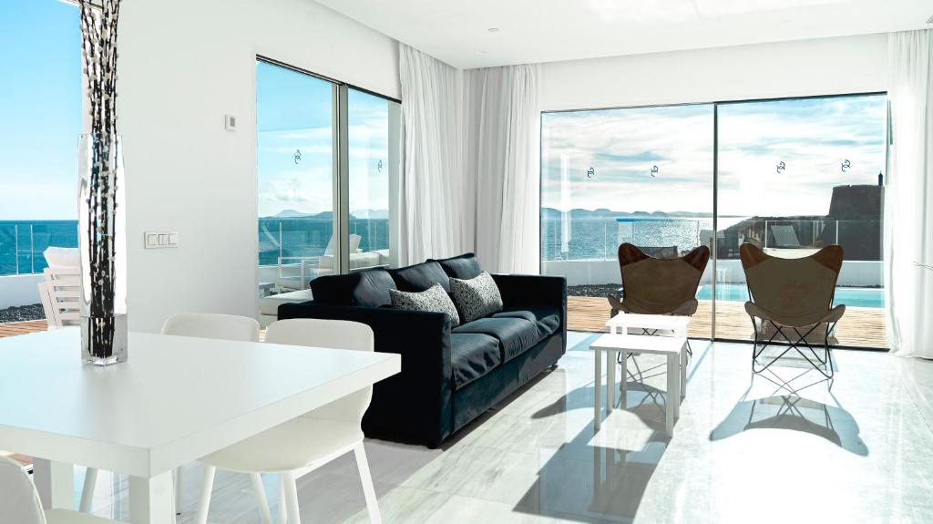 a living room with a couch and a table and chairs at CalaLanzarote Suites Hotel - Adults Only in Playa Blanca