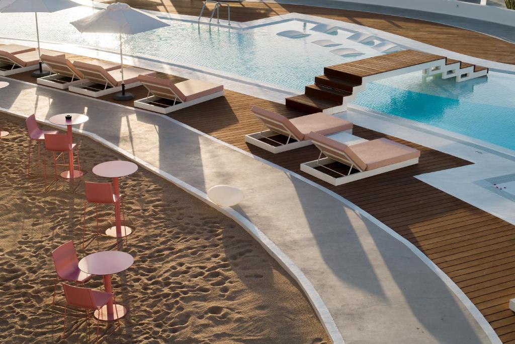 an overhead view of a swimming pool with chairs and tables at CalaLanzarote Suites Hotel - Adults Only in Playa Blanca
