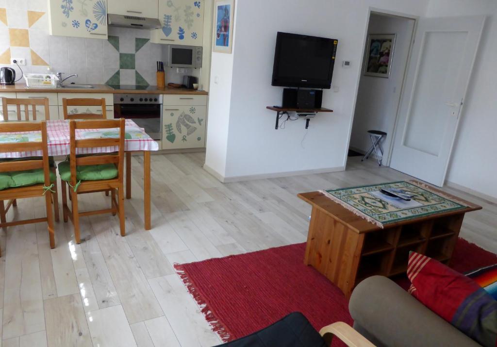 ein Wohnzimmer mit einem Tisch und einer Küche in der Unterkunft Ferienwohnung Sailer in Gmunden