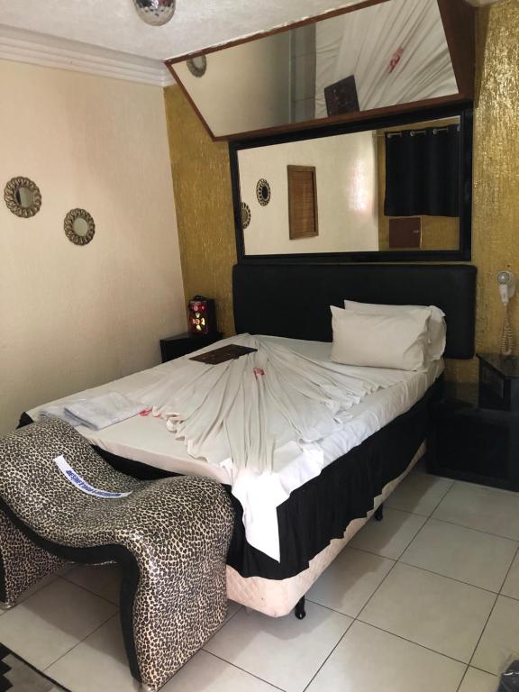 um quarto com uma cama com um espelho e uma cadeira em HOTEL MEDIEVAL em São Paulo