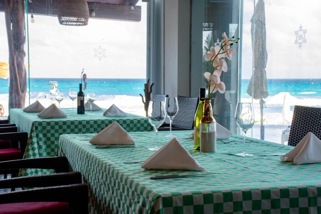 ein Tisch mit einer grünen Tischdecke und Weingläsern in der Unterkunft Ocean Dream Cancun by GuruHotel in Cancún