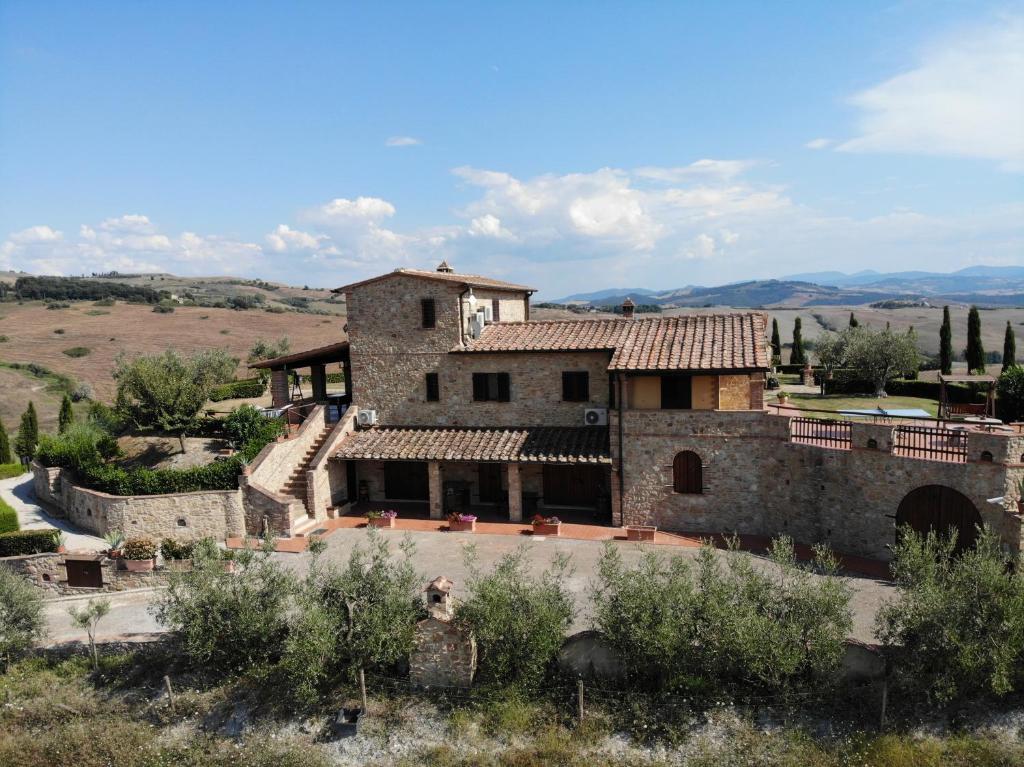 una vecchia casa in pietra in mezzo a un campo di Agriturismo Casa al Povero a Volterra