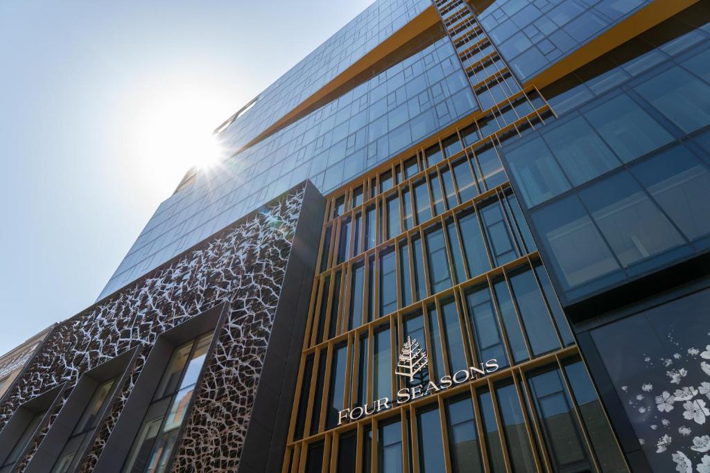 a tall glass building with the sun shining on it at Four Seasons Hotel Montreal in Montréal