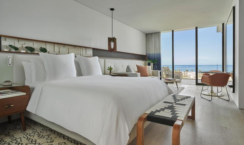 a bedroom with a large white bed with a view of the ocean at Four Seasons Resort Los Cabos in La Ribera