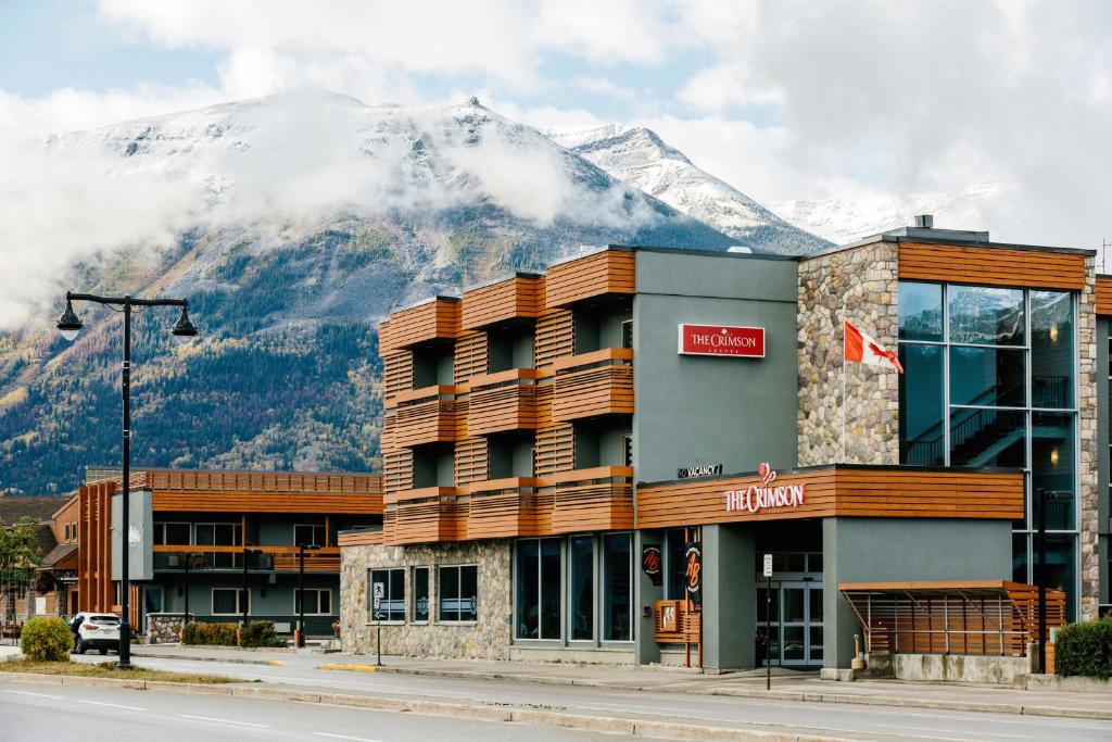 a hotel with a snow covered mountain in the background at The Crimson Jasper in Jasper