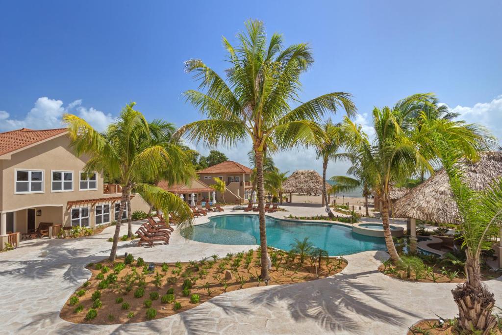 una vista aérea de un complejo con piscina y palmeras en Sirenian Bay Resort -Villas & All Inclusive Bungalows, en Placencia Village