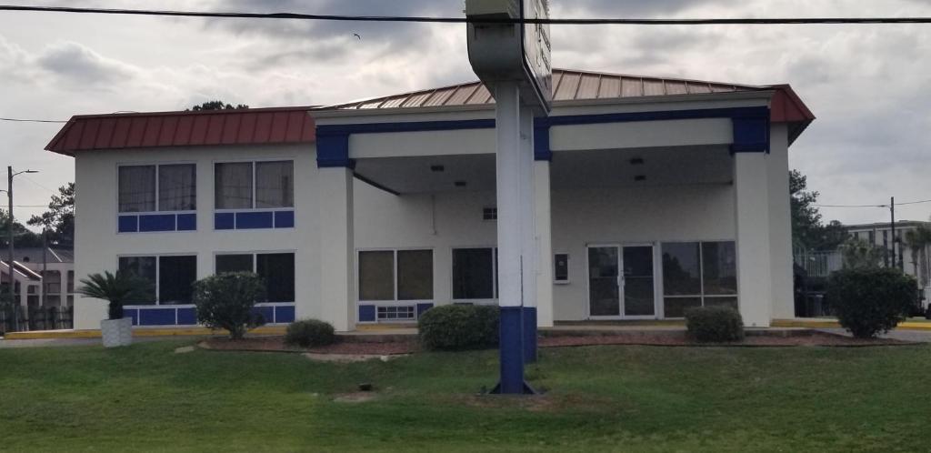 a large white building with a red roof at Family Inns of America - Mobile in Mobile