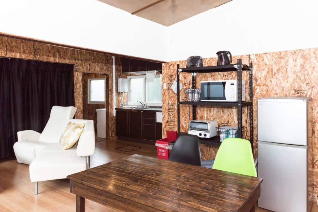 eine Küche und ein Wohnzimmer mit einem Tisch und Stühlen in der Unterkunft Hakodate House in Hakodate