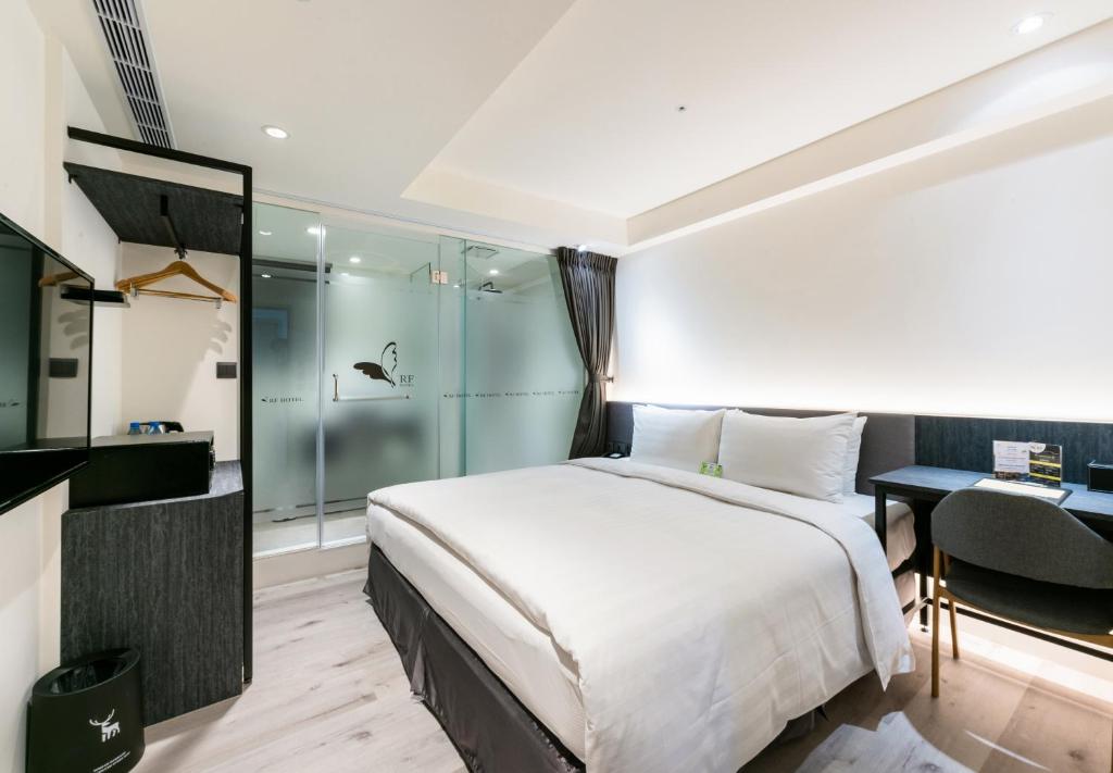 a bedroom with a bed and a desk and a shower at RF Hotel - Zhongxiao in Taipei