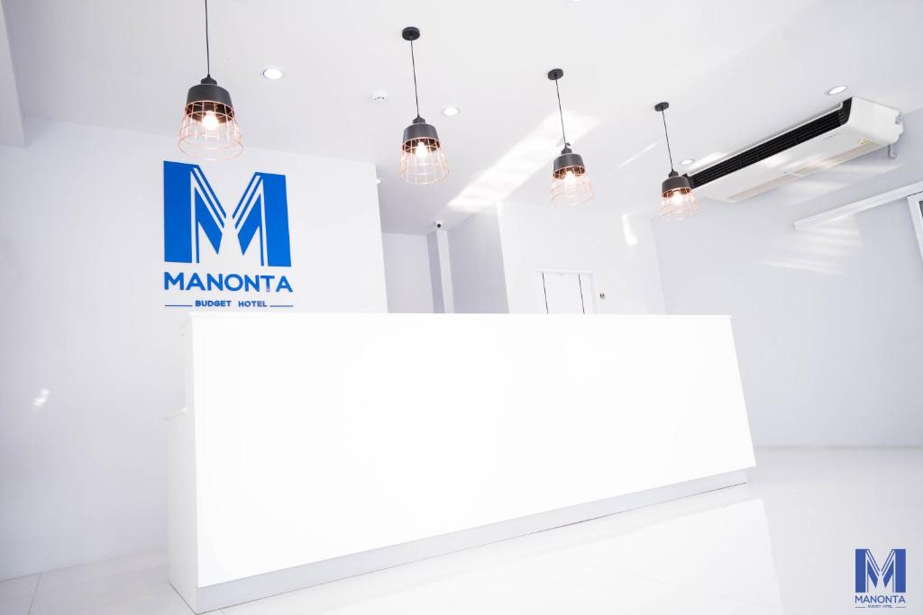 合艾的住宿－Manonta Budget Hotel，房间里的白色柜台上有一个标牌