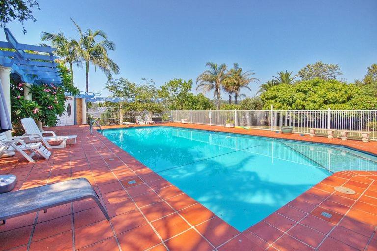a large swimming pool with two chairs next to at Melville House Bed and Breakfast in Lismore