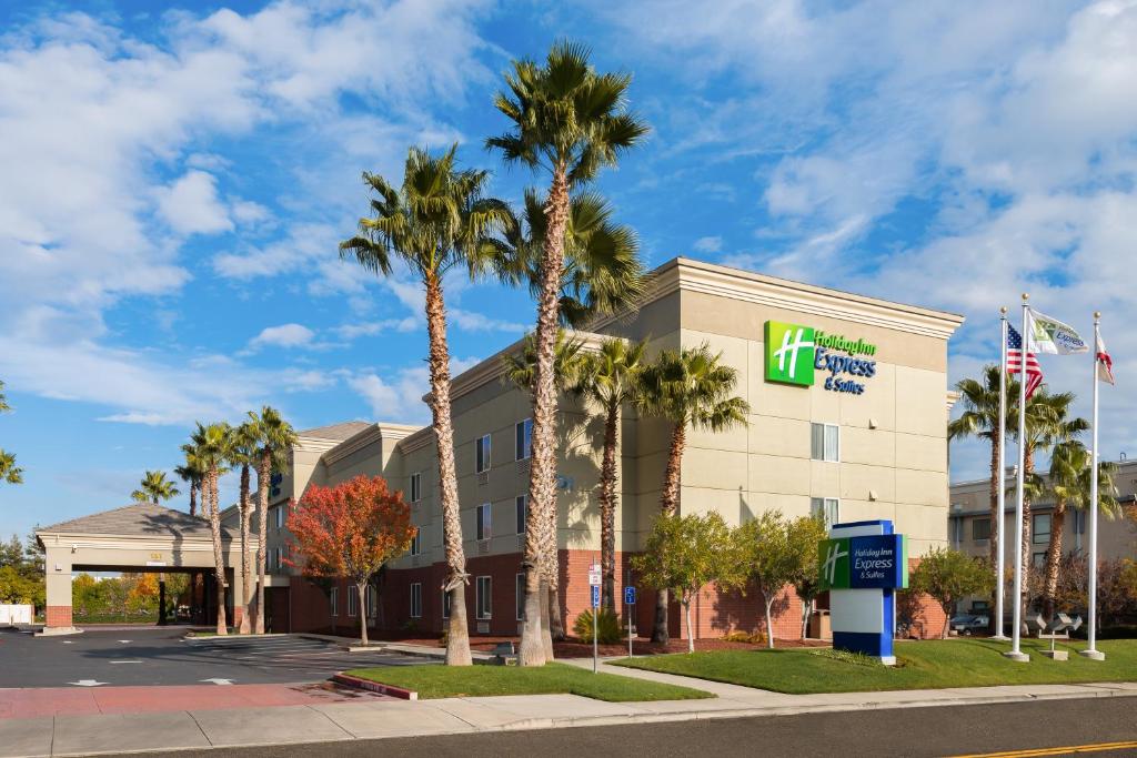 a hotel with palm trees in front of a building at Holiday Inn Express Hotel & Suites Vacaville, an IHG Hotel in Vacaville