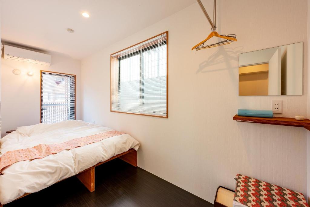 1 dormitorio con cama y ventana en plat hostel keikyu asakusa karin, en Tokio