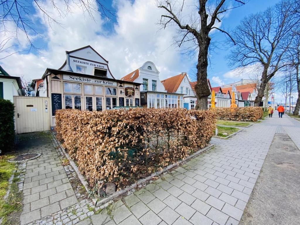a large house with a hedge in front of it at Stromkaje in Warnemünde