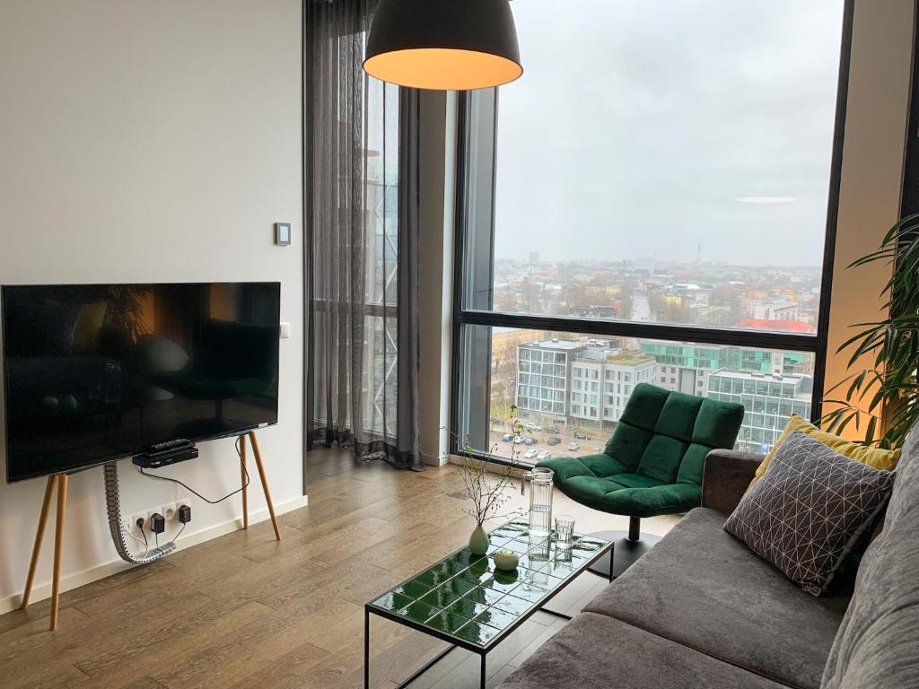 a living room with a couch and a large window at Orange Apartments Tower & Free Parking in Tallinn