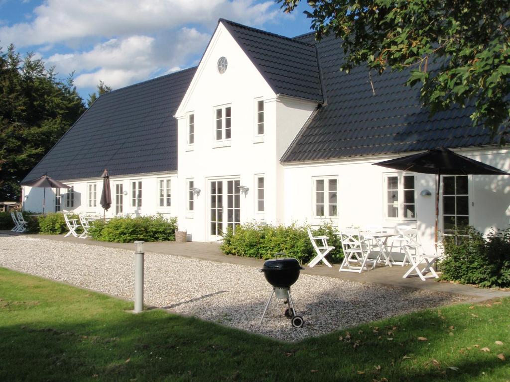 ein weißes Haus mit Grill davor in der Unterkunft Svendlundgaard Apartments in Herning