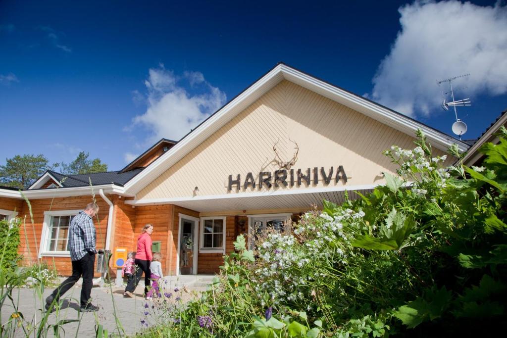 duas pessoas a andar em frente a um edifício de harrahmite em Harriniva Adventure Resort Cabins em Muonio