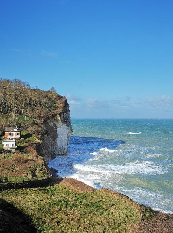une maison sur une falaise à côté de l'océan dans l'établissement Studio vue mer L échappée normande, à Saint-Pierre-en-Port
