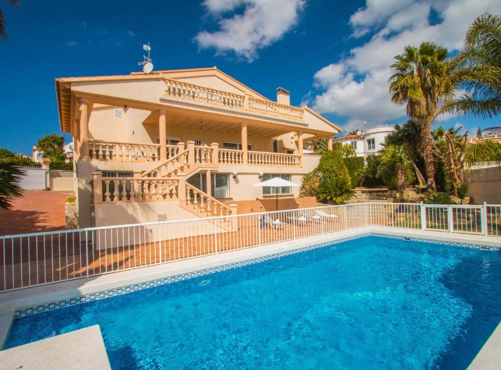 a villa with a swimming pool and a house at Villa Calypso - Plusholidays in Calpe