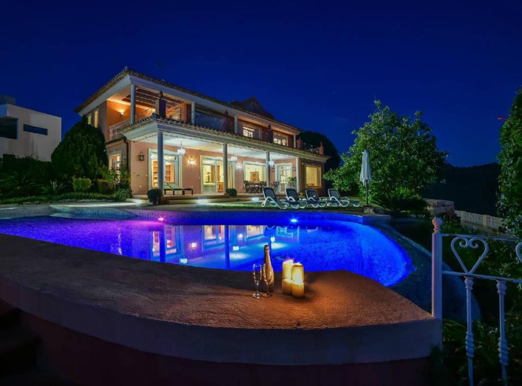 a house with a swimming pool at night at Villa Eden - Plusholidays in Calpe