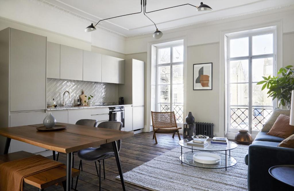 een woonkamer met een tafel en een keuken bij Modern 1 Bedroom Apartment - minutes from Angel Tube St. in Londen