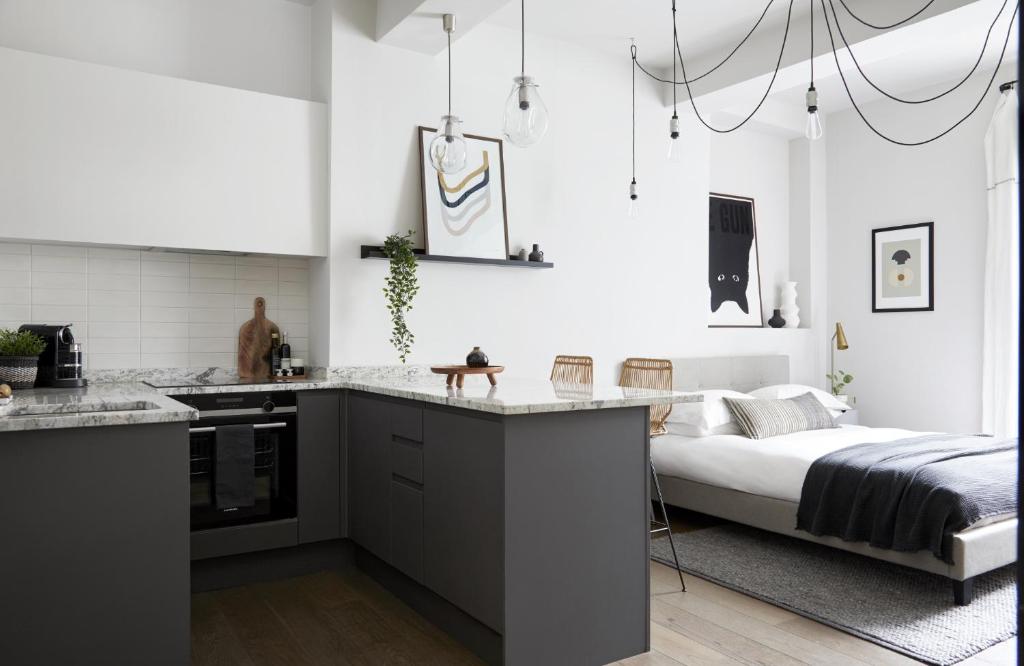 cocina y dormitorio con cama de fondo en Contemporary Studio - minutes from Angel Tube St. en Londres