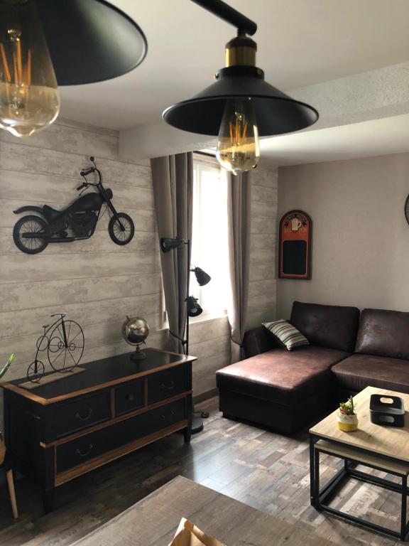 a living room with a couch and a motorcycle on the wall at Le velocipede in Aumale