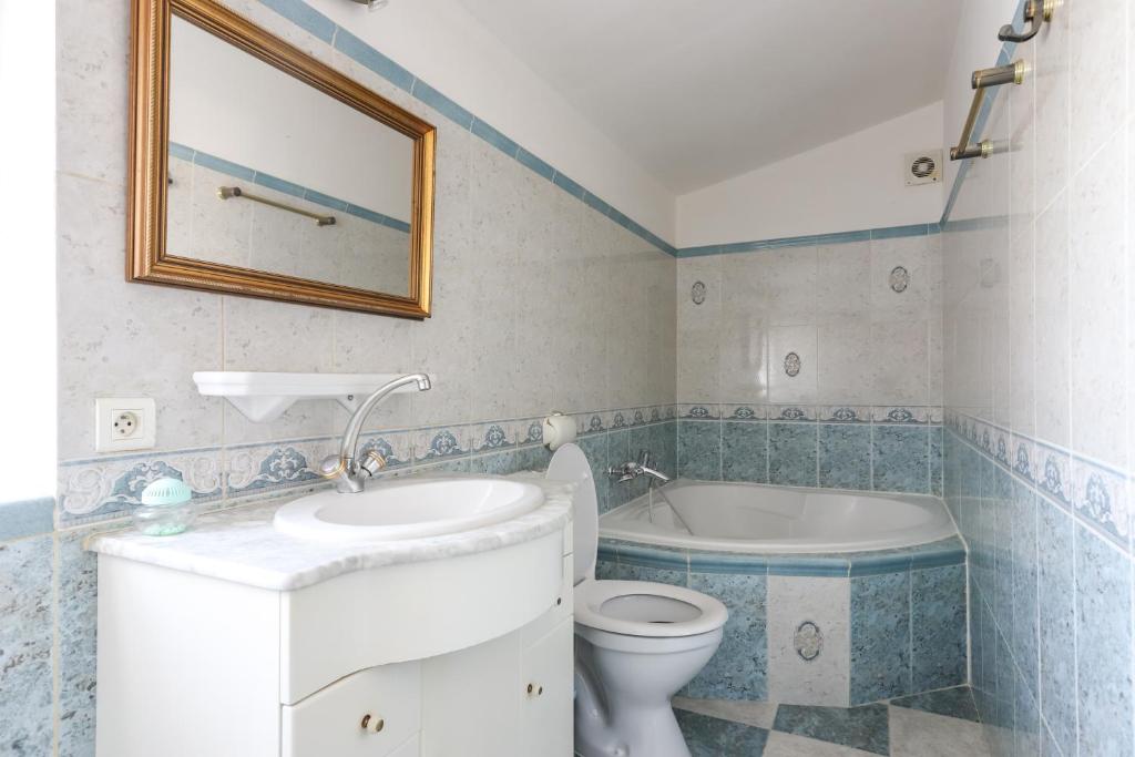 a bathroom with a toilet and a sink and a bath tub at Le Mas du Lac in Saint-Rémy-de-Provence