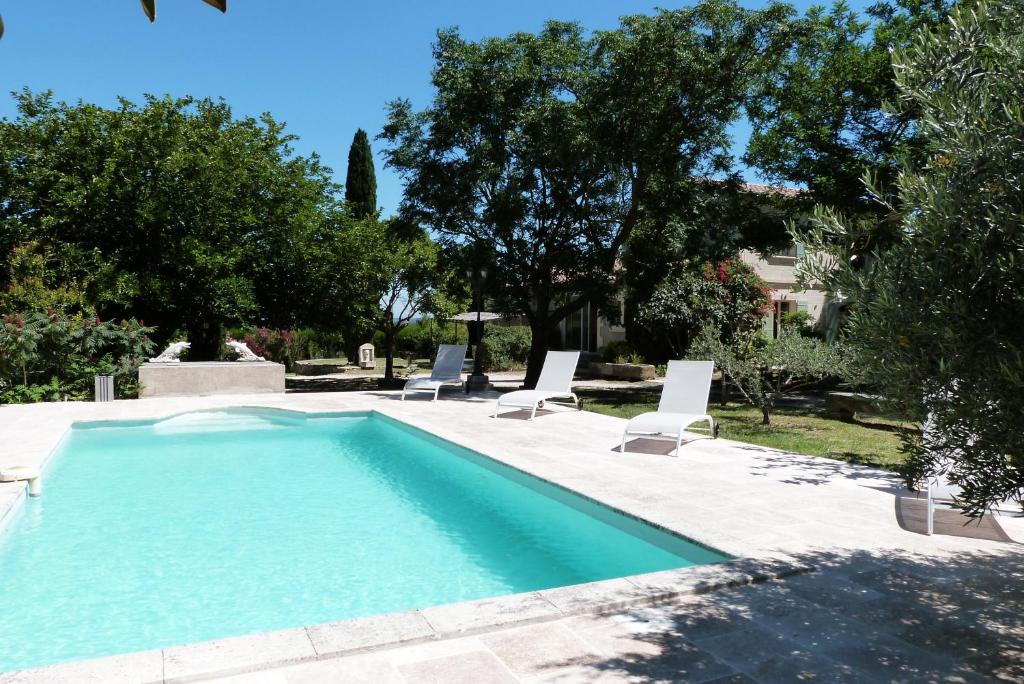 a swimming pool with two lounge chairs and a pool at Le Mas du Lac in Saint-Rémy-de-Provence