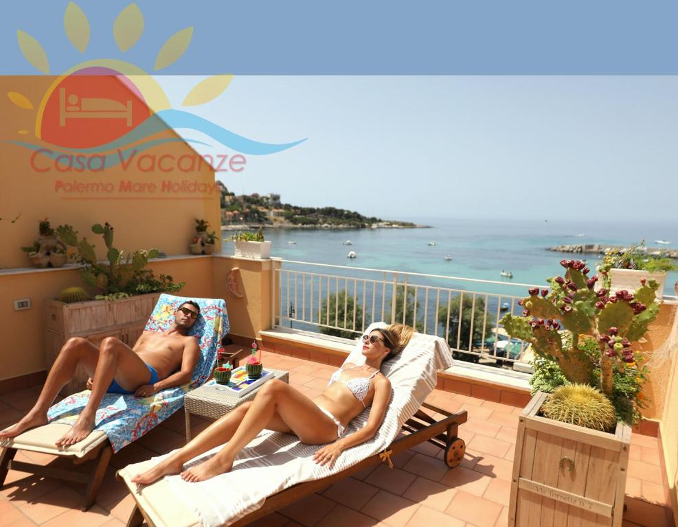 斯費拉卡瓦洛的住宿－Palermo Mare Holidays，两名穿着泳衣的女性坐在阳台上