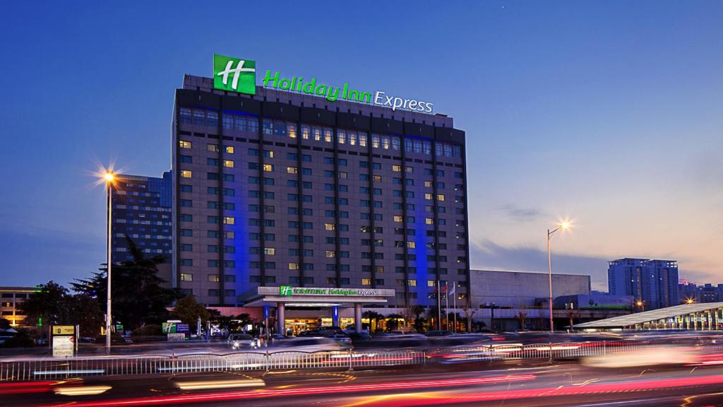 Un edificio alto con un cartel encima. en Holiday Inn Express Zhengzhou Zhongzhou by IHG, en Zhengzhou