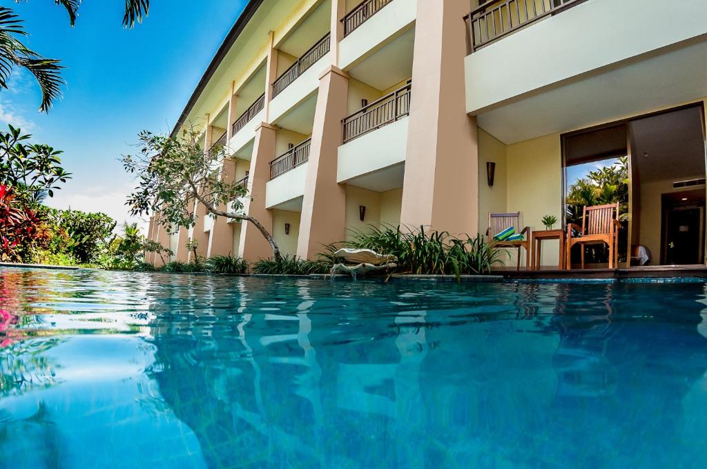 a swimming pool in front of a building at The Natsepa Resort and Conference Center in Ambon