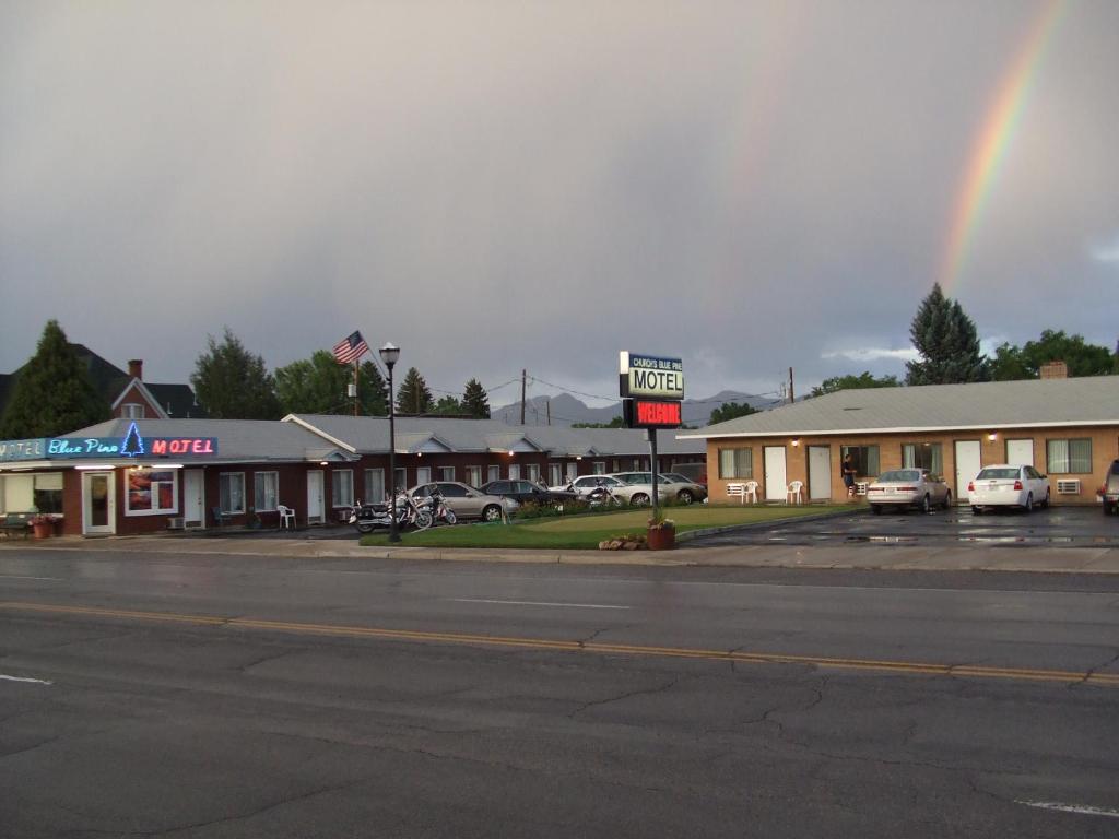 a rainbow in the sky over a parking lot at Blue Pine Motel in Panguitch